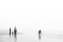 family standing on a beach 