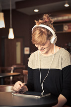 woman wearing headphones looking at an iPad