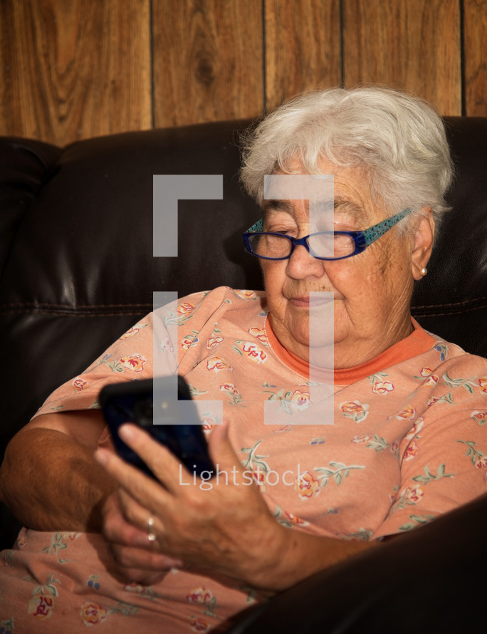 elderly woman looking at a cellphone screen 