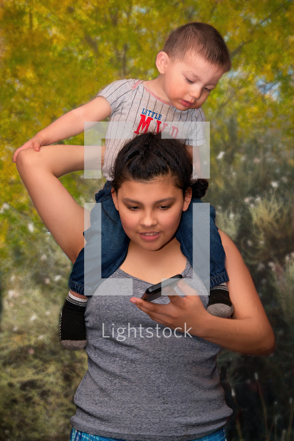 brother and sister looking at a cellphone screen 