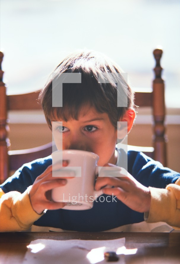 child drinking from a mug 