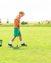 a boy child playing golf 