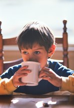 child drinking from a mug 