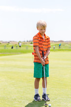 boy child playing golf 