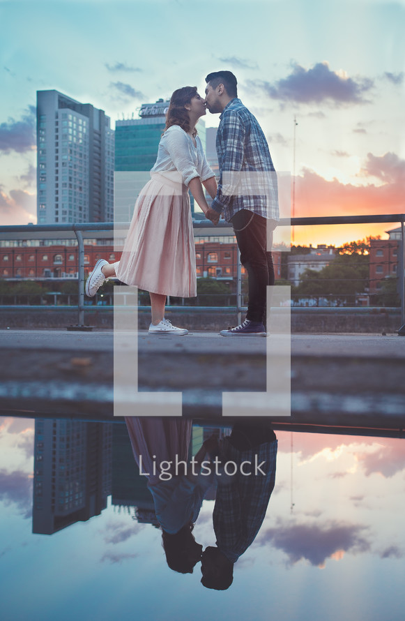a couple kissing in front of a city 