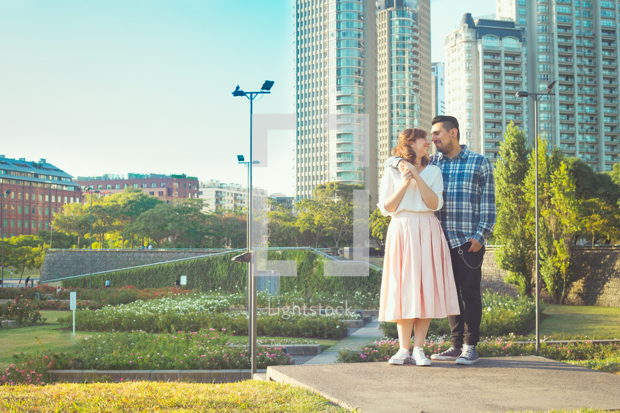 a couple standing in front of a city 