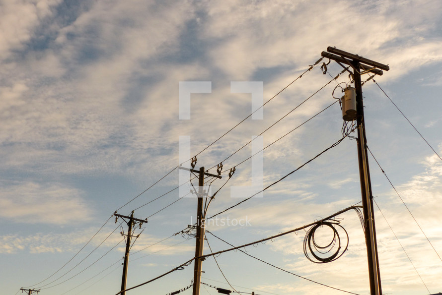 power lines and power poles with clouds in the blue sky
