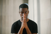 African American young man with praying hands 