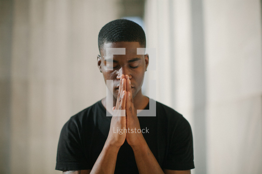 African American young man with praying hands 