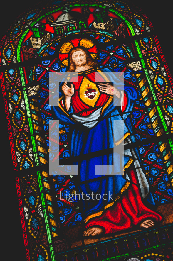 A stained-glass window depicting Jesus and the sacred heart symbol
