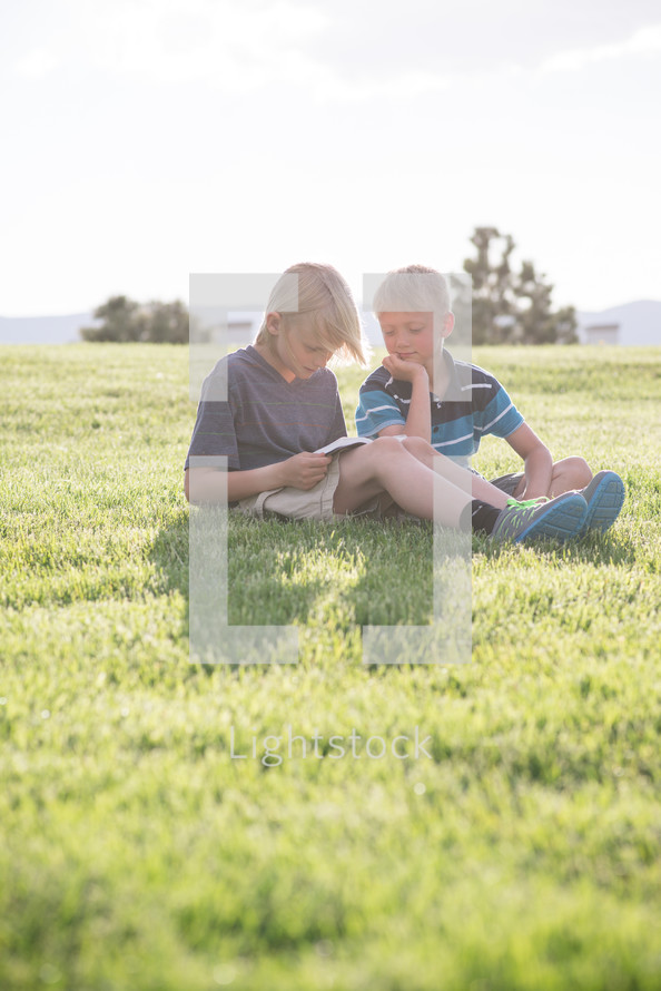 brothers reading Bibles in the grass 