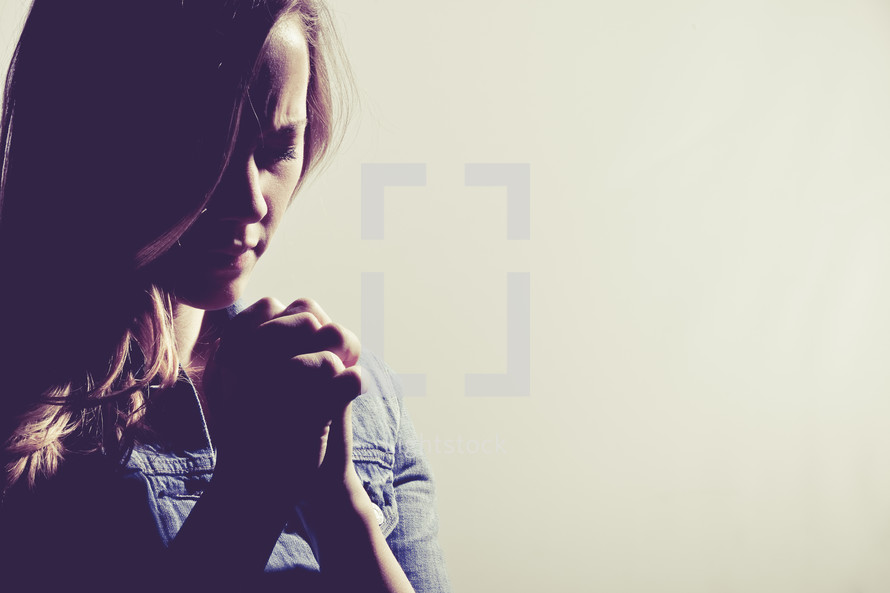 woman in prayer against a white background