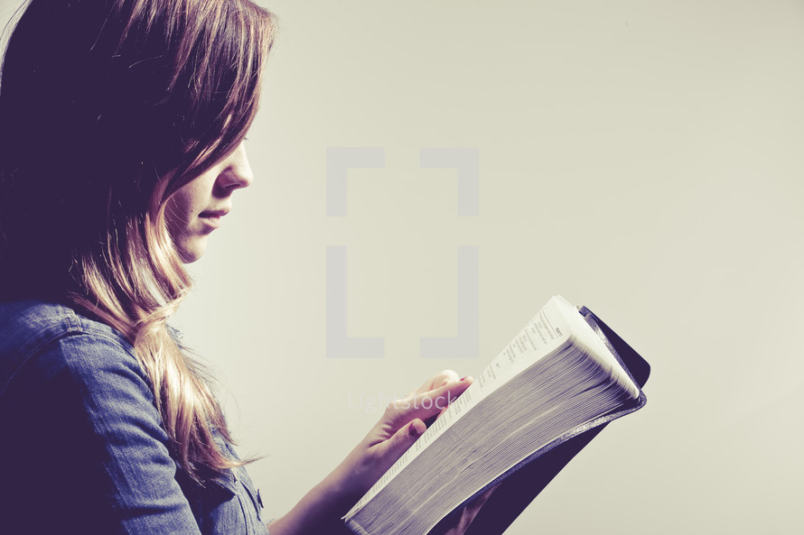 woman reading a Bible against a white background