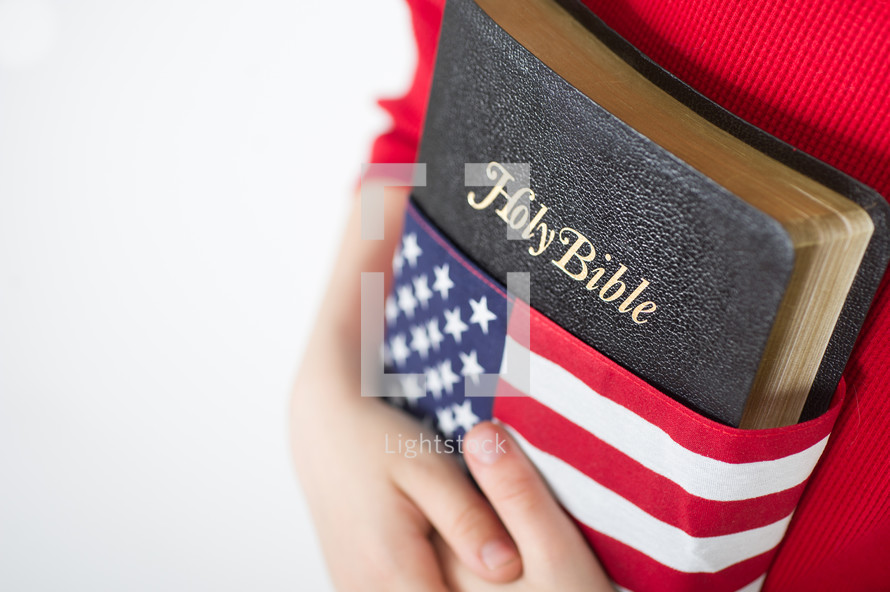 Holding a Holy Bible wrapped in an American flag.