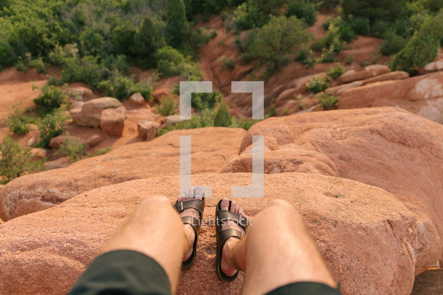 feet at the edge of a red rock cliff 