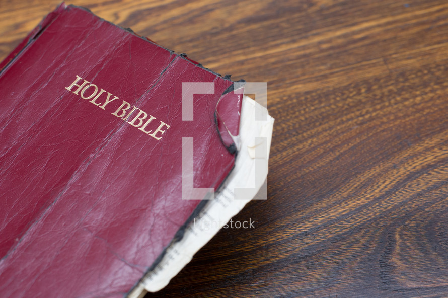 Tattered Bible on a wood table.