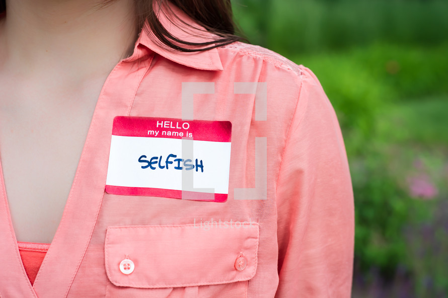 woman wearing a name tag - selfish 