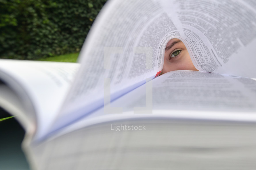 Concept Girl Lying In Grass And Reading Book