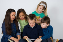 Children reading the Bible together.