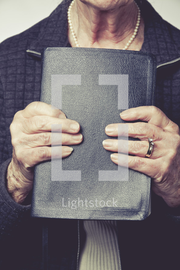 elderly woman holding a Bible