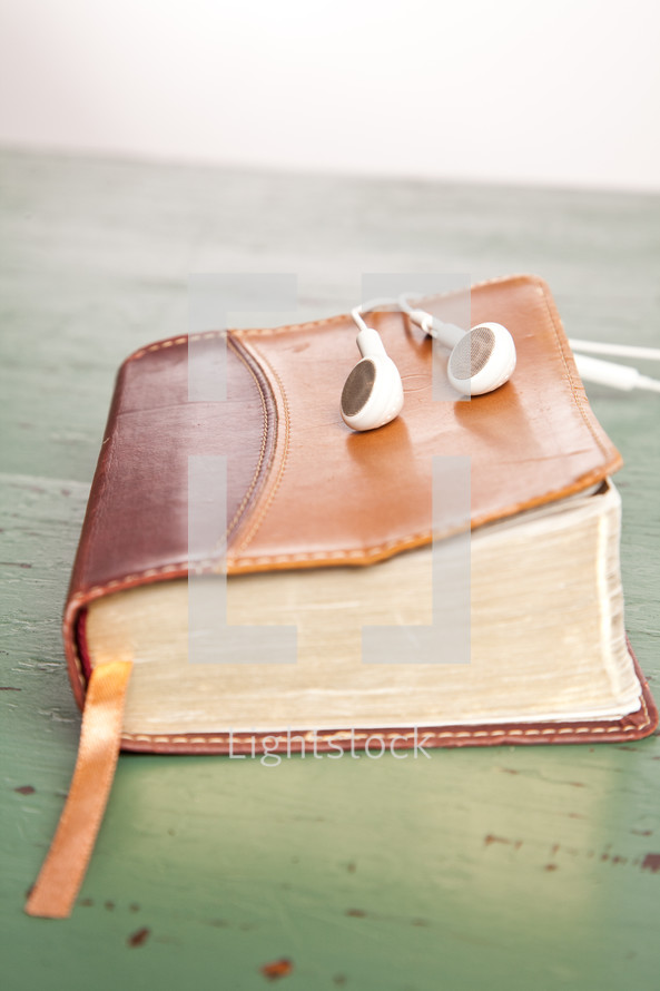 earbuds resting on a Bible