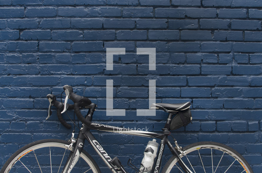 a bike leaning against a brick wall 