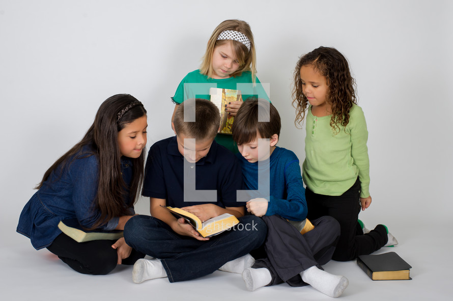 Children reading the Bible together.