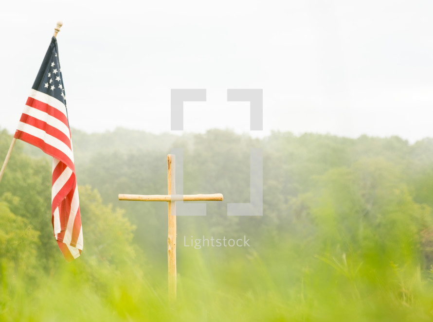 a cross and american flag in a field