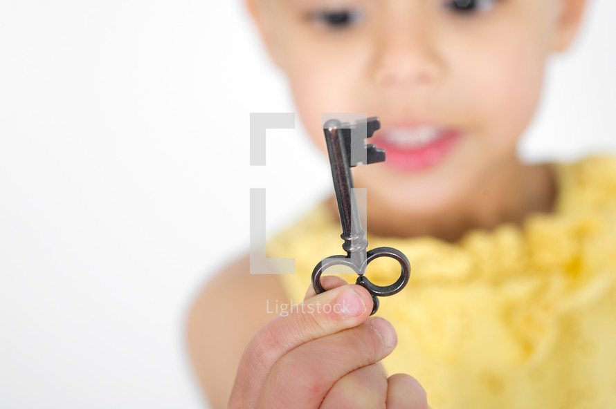 Large black key being held by a little girl