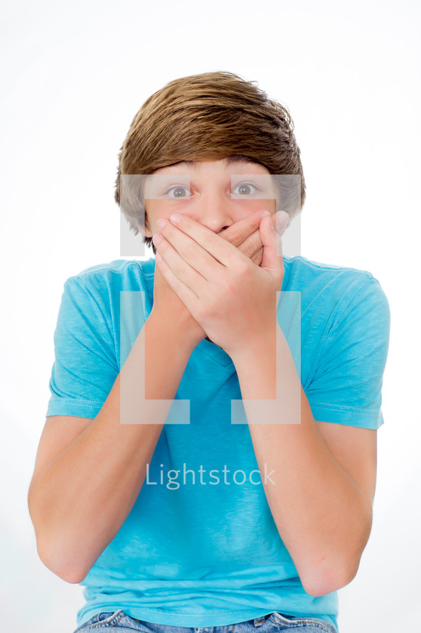 teen boy covering his mouth