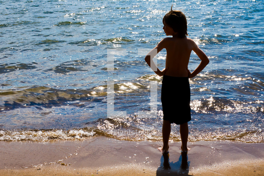 Boy standing at the ocean shore.