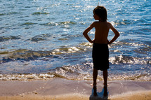 Boy standing at the ocean shore.