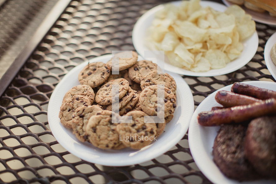 chips, cookies, hotdogs, and hamburgers on a table 