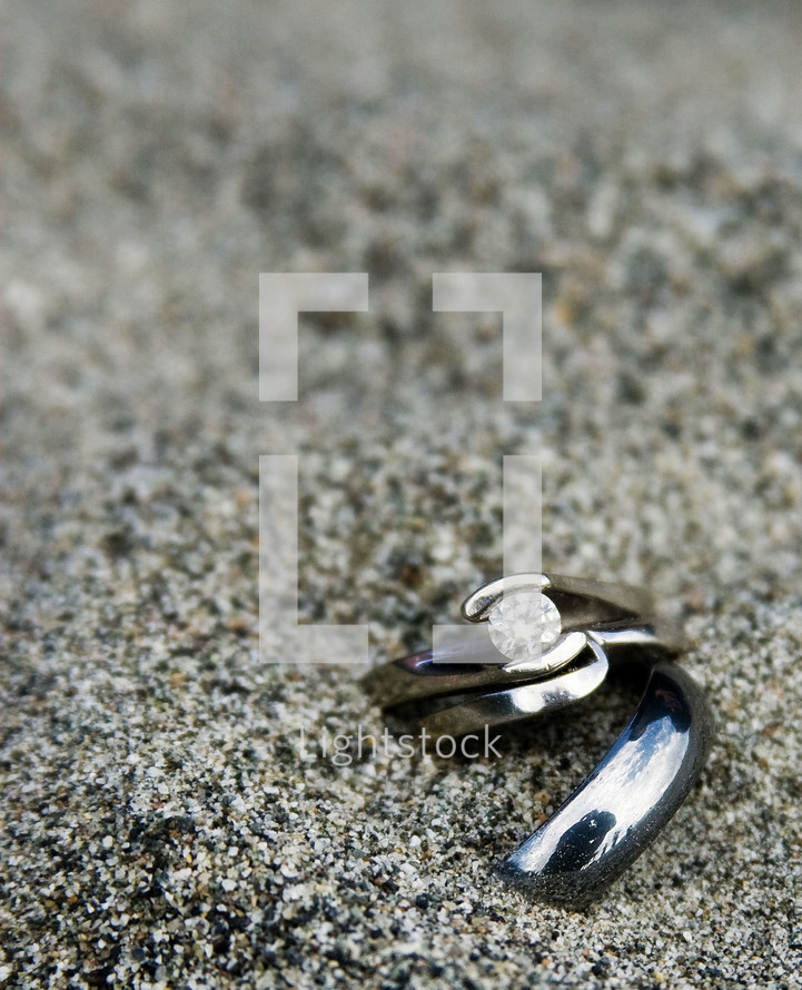 Wedding rings in the sand.