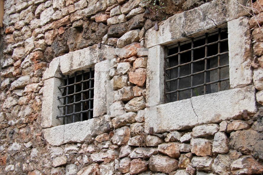 Hand made antique prison bars in stone walls.
