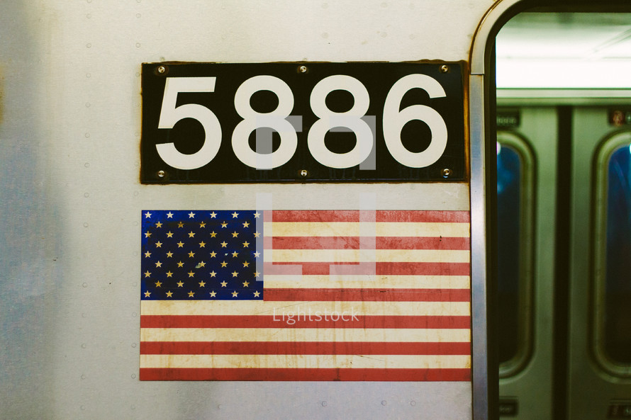 5886 and American flag on the side of a subway train 
