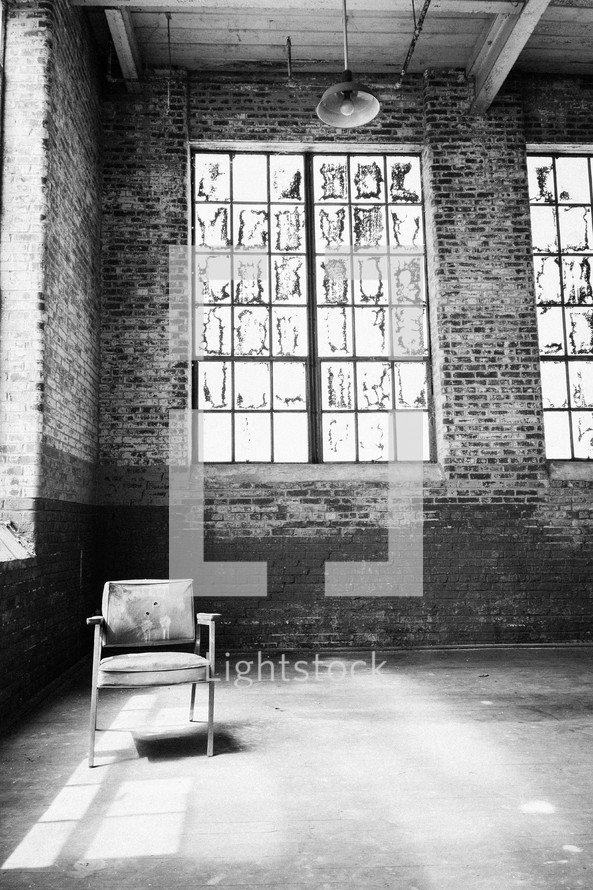 Chair in front of windows in an empty loft.