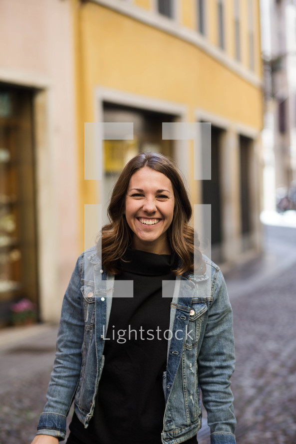 woman standing in the middle of a cobblestone street 
