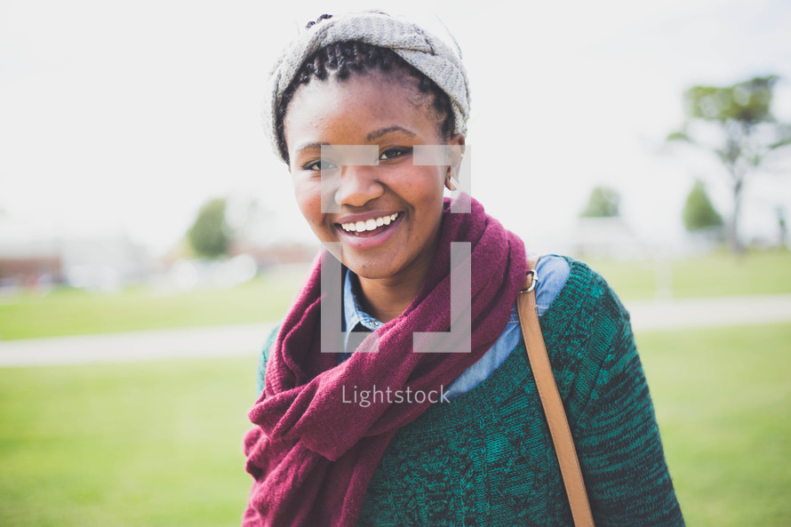 a smiling teenage girl in a scarf 