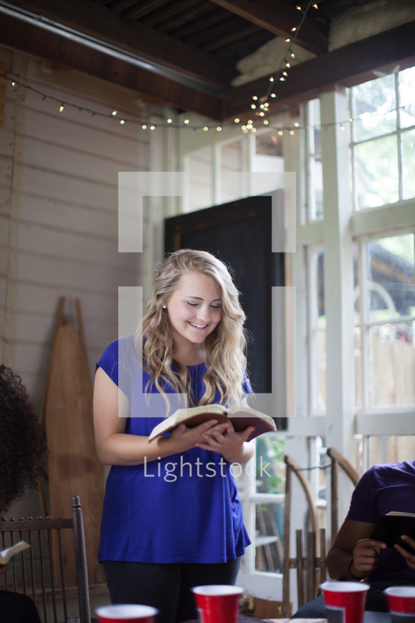 woman reading a  Bible to a group at a Bible study 