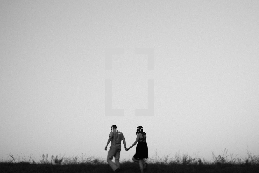 couple walking outdoors holding hands 
