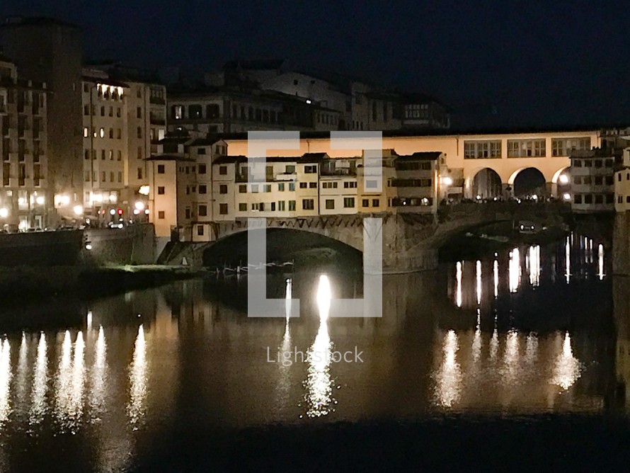 bridge over a canal and lights reflecting on the water at night 