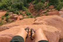 feet at the edge of a red rock cliff 