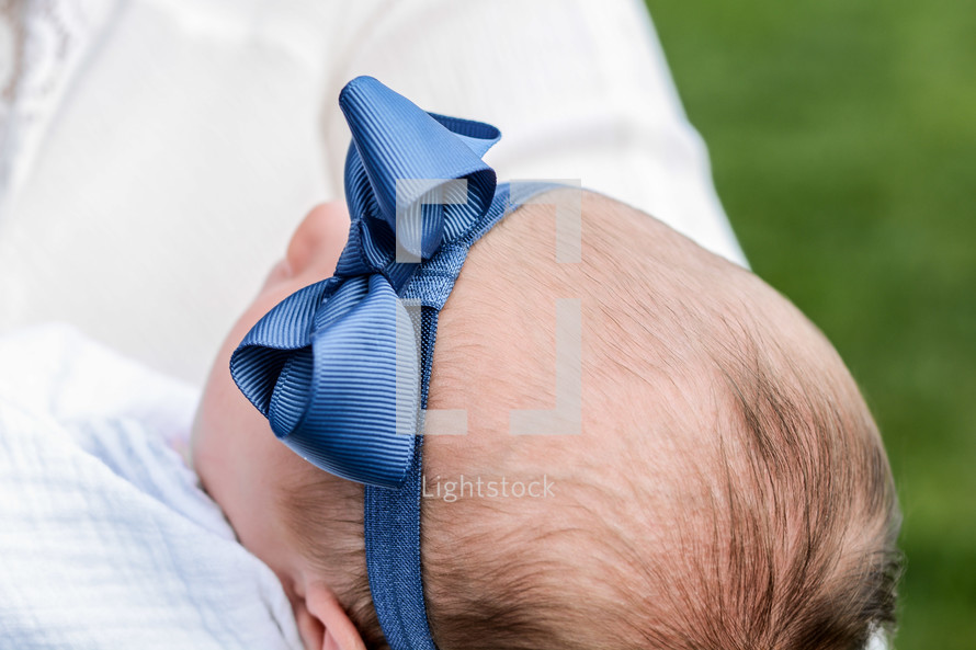 a newborn girl with a bow on her head 