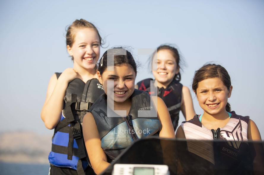 kids on a boat in life vests 