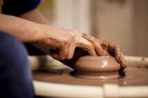 hands on clay on a potter's wheel 