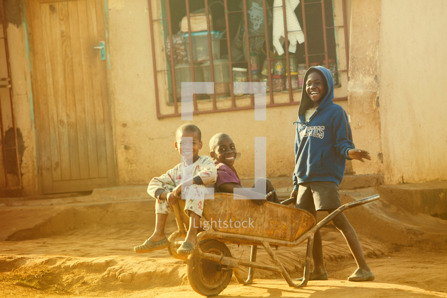 Children in a wheelbarrow in Malawi, Africa. 