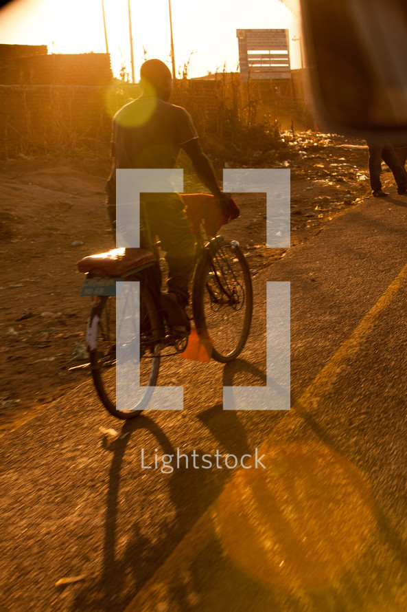 A man riding a bicycle in Malawi, Africa. 