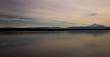 distant snow capped mountains across a lake 