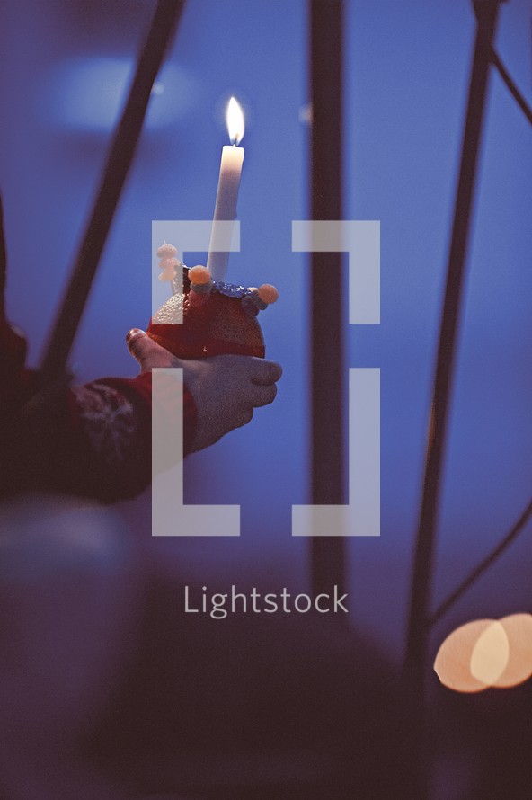 hand holding a candle at a Christmas Eve service 